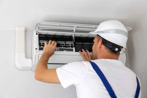Technician inspecting the filters of an indoor wall-mounted air conditioner